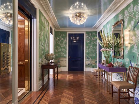 Wide-plank mahogany-toned chevron parquet with inlaid border in an Upper East Side entry gallery with hand-painted chinoiserie wallpaper, private elevator, and ornate chandelier, installed by I.J. Peiser's Sons.