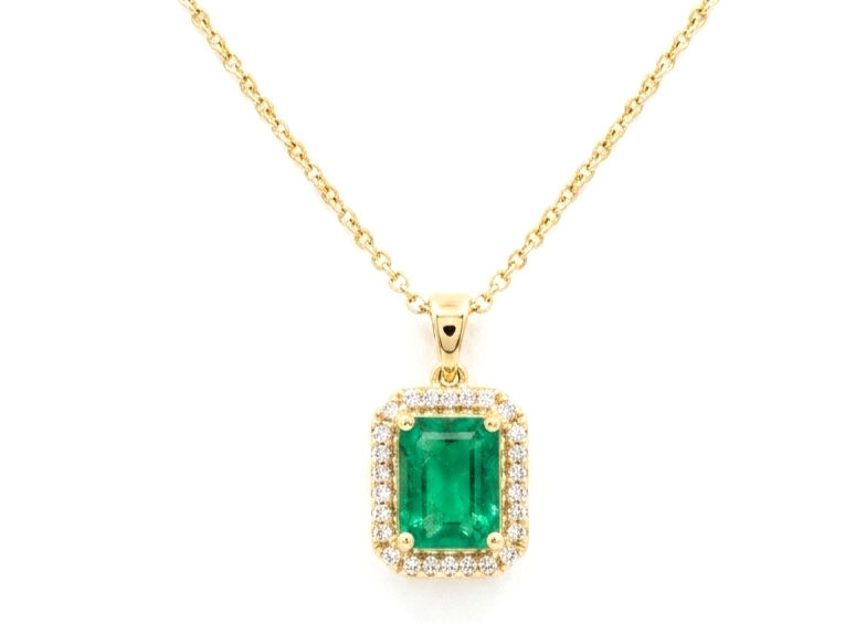 Emerald is surrounded by a halo of diamonds in 18kt yellow gold