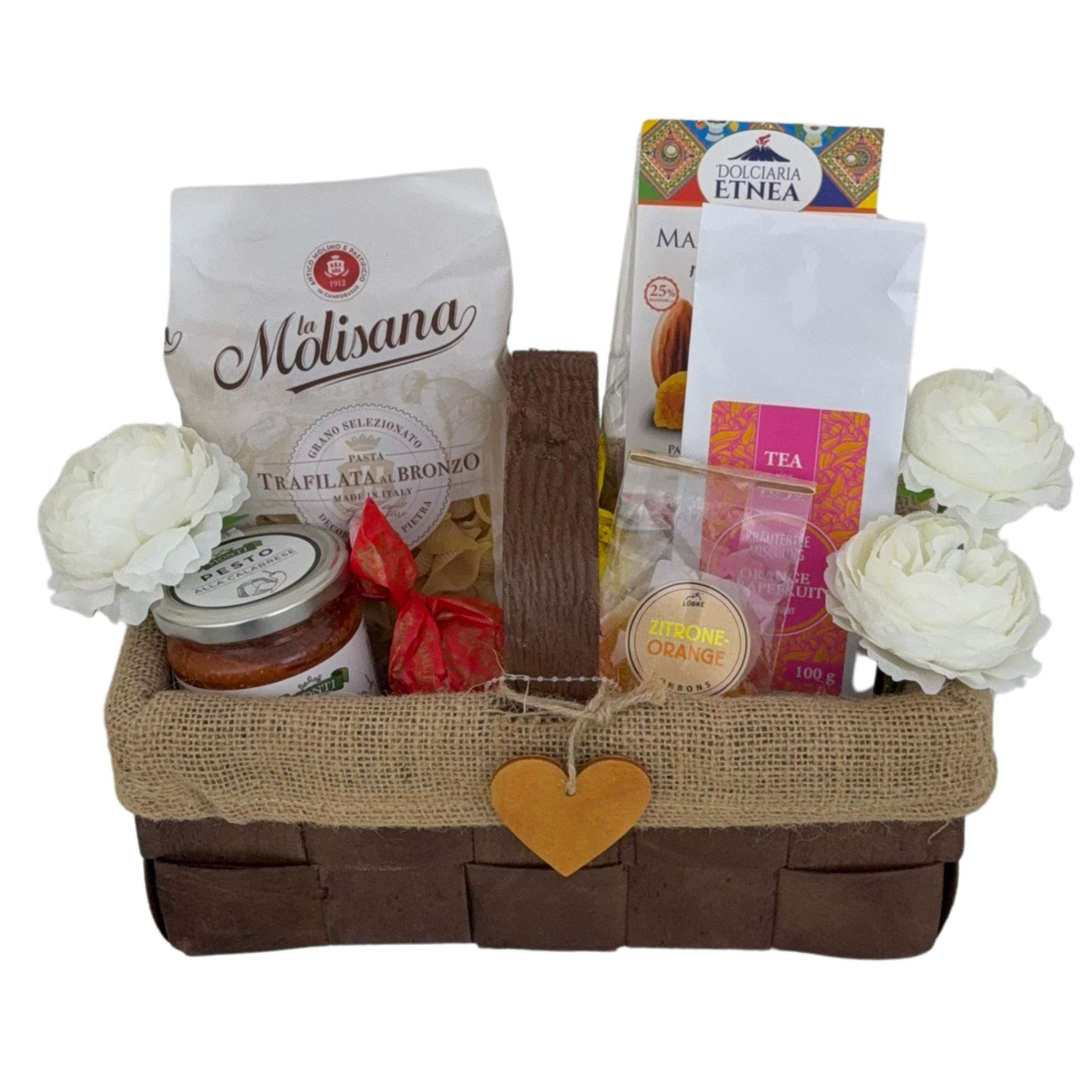 Geschenkkorb mit Pasta Pesto Tee und Zitrus Süßwaren in warmen Orange Naturtönen.