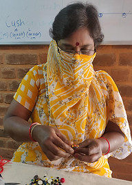 An embroidery artisan crafting a fish doll