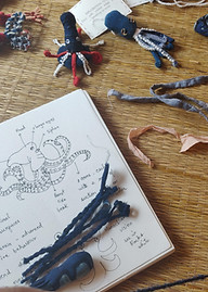 A notebook showing a study sketch of an octopus surrounded by octopus doll fabric explorations