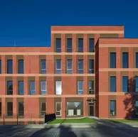 Front elevation of an academic building clad in Bengali Sunrise thin brick in king size, with symmetrical window placement and contrasting horizontal architectural bands.