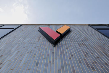 Upward view of the Momentive façade with logo mounted on Obsidian Shadow thin brick in American Imperial size.