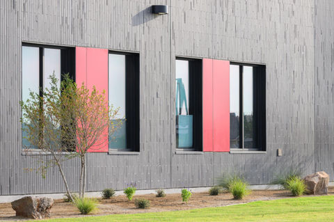 Window detail on Dorothy Martinez Elementary School featuring Black Beauty thin brick in American Imperial size by Acme, contrasted with bold red accent panels.