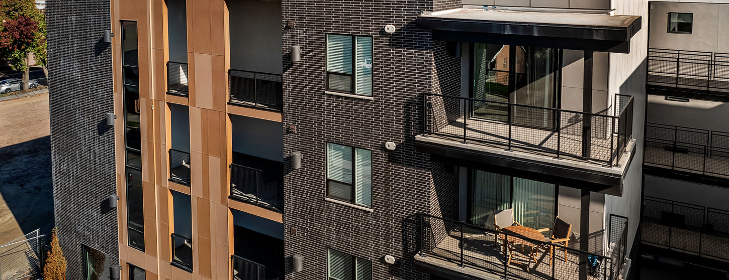 Streetcar Flats in Salt Lake City Utah are accented with Black Beauty thin brick in Norman size. This is an angled view of the side building and some balconies with the mountains lining the horizon.