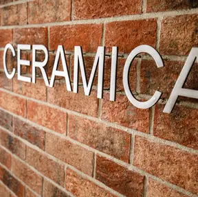 Angled detail of Hotel Ceramica signage installed on Brick Street thin brick in King Size, showcasing the brick’s warm red hues and textured surface.