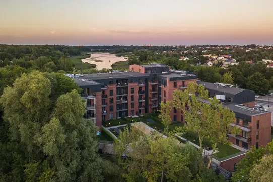 Courtyard perspective of apartments built with Old Factory thin brick in King size, where the elongated brick format enhances horizontal lines and showcases blended red, brown, and dark accent tones.