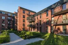 Detailed façade view featuring Old Factory thin brick in King size, revealing subtle surface texture and a harmonious mix of warm reds and deeper, smoky undertones.