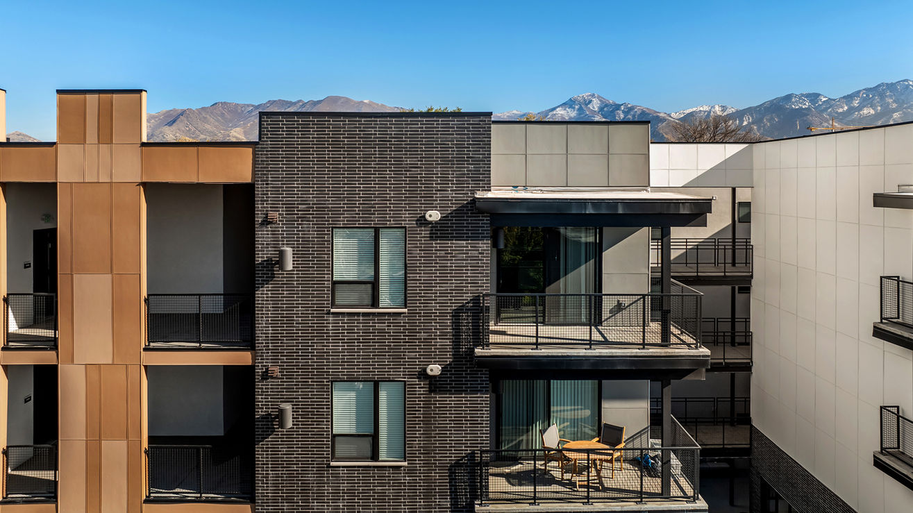 Streetcar Flats in Salt Lake City Utah are accented with Black Beauty thin brick in Norman size. This is a view of a few apartments of the building with the mountains peaking over.