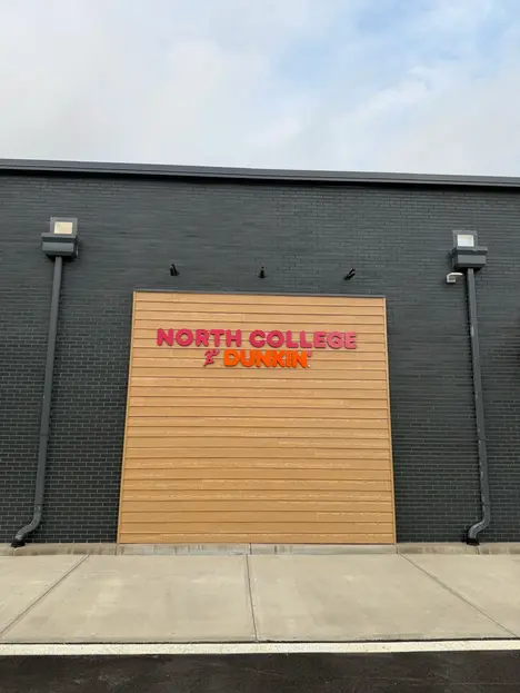 Modern Dunkin’ restaurant exterior using Manganese modular thin brick, 7 5/8 x 2 1/4 inch thin brick, paired with aluminum window framing and wood-look accent panels
