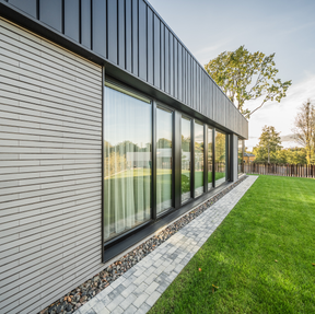 This is a residential home with Misty Morning thin brick in imperial size with morning light dancing off the facade side of building at angle.