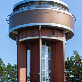 Modern circular water tower featuring Ruby Red imperial brick and metal cladding