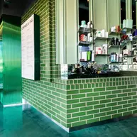 Modern skincare retail space with Green Valley Glazed King Size thin brick walls and custom shelving in Los Angeles.