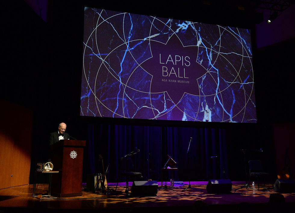 Prince Amyn Aga Khan in front of a a large Lapis Ball screen