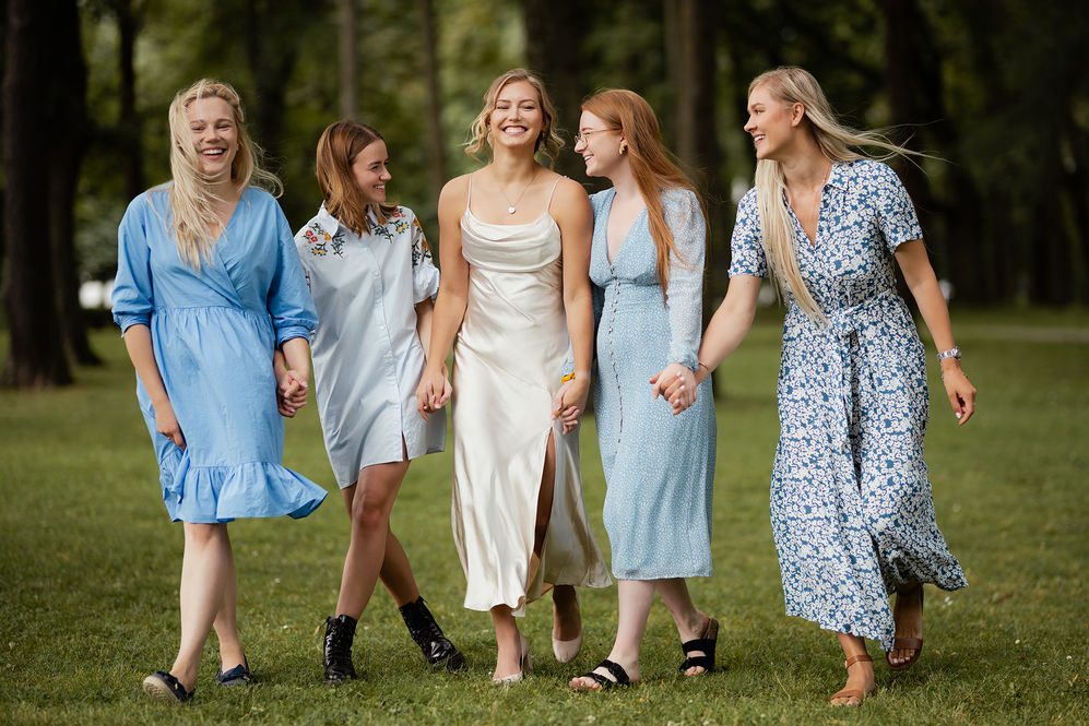 Girls with blue dresses holding hands and walking together