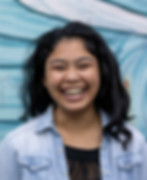 Jodie Aguinaldo, Chorus Studio voice teacher, smiling in a bright headshot with long dark hair and a blue top