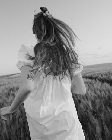 Mustvalge pilt naisterahvast, jooksmas kevadise Eesti põllu peal.