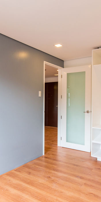 Modern bedroom with gray wall, wood floors, and built-in shelving