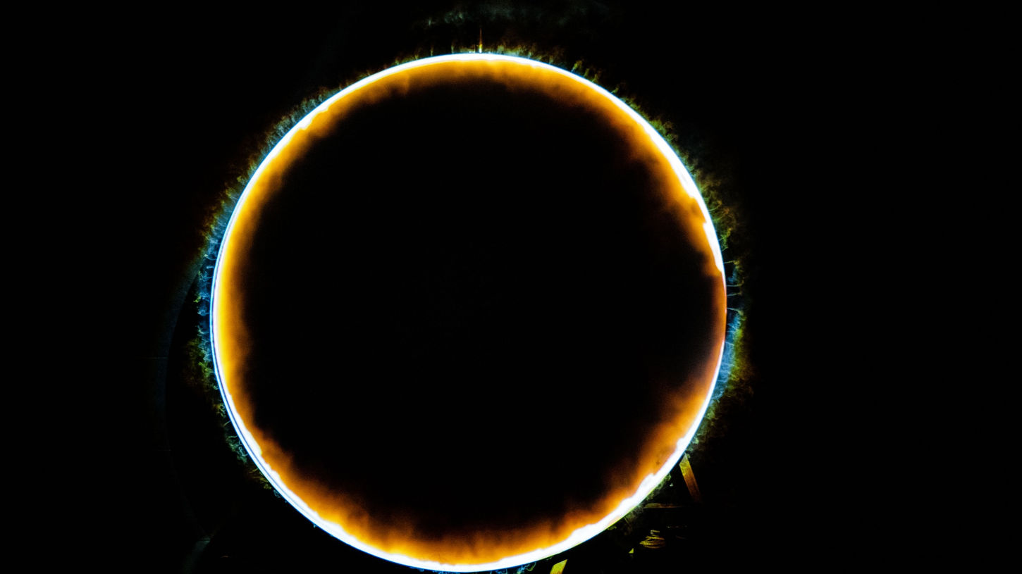 A large, hung moon with the projected image of a smoky orange circle lining the edge.