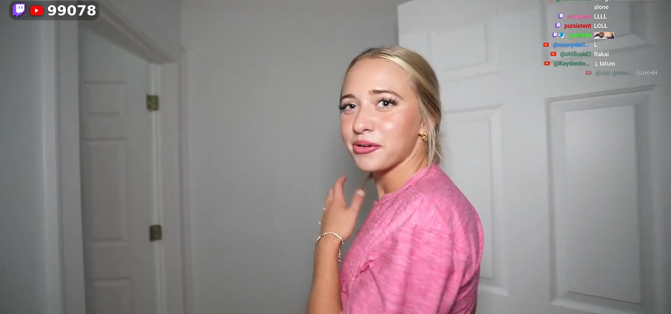Blonde woman in a pink shirt turns in a white hallway, with livestream chat overlay and 99078 viewer count in the corner.
