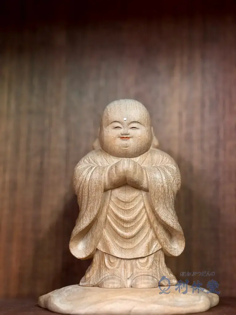 「おぶつだんの利休堂」の店内に展示されている、大仏師 松本明慶氏作の「童地蔵」。ふくよかで柔らかな笑顔が特徴的な仏像が、見る人に安らぎを与えています。