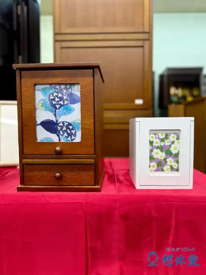 長崎市の仏壇・仏具店「おぶつだんの利休堂」の店内に展示された、ブラウンとホワイトの2種類のペット仏壇。インテリアに馴染むシンプルで可愛いコンパクトなデザイン。