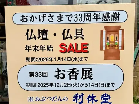 長崎市の仏壇・仏具店「おぶつだんの利休堂」の店舗玄関外に掲げられた布看板。カラフルな文字で「第33回お香展」と「年末年始SALE」の開催が告知されており、来店客の目を引くデザインです。
