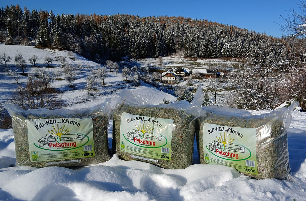 Drei Bio Heu für Kleintiere Packungen vor verschneiter Landschaft. Bio Heu für Kleintiere kaufen