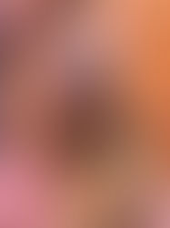 D. Elaine Corbin Hall is an older Black woman with silver grey hair and glasses, wearing a pink sweater and smiling.