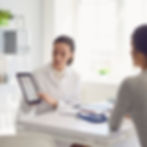 A doctor is reviewing information on a tablet with a patient, possibly explaining details about Endometriosis.
