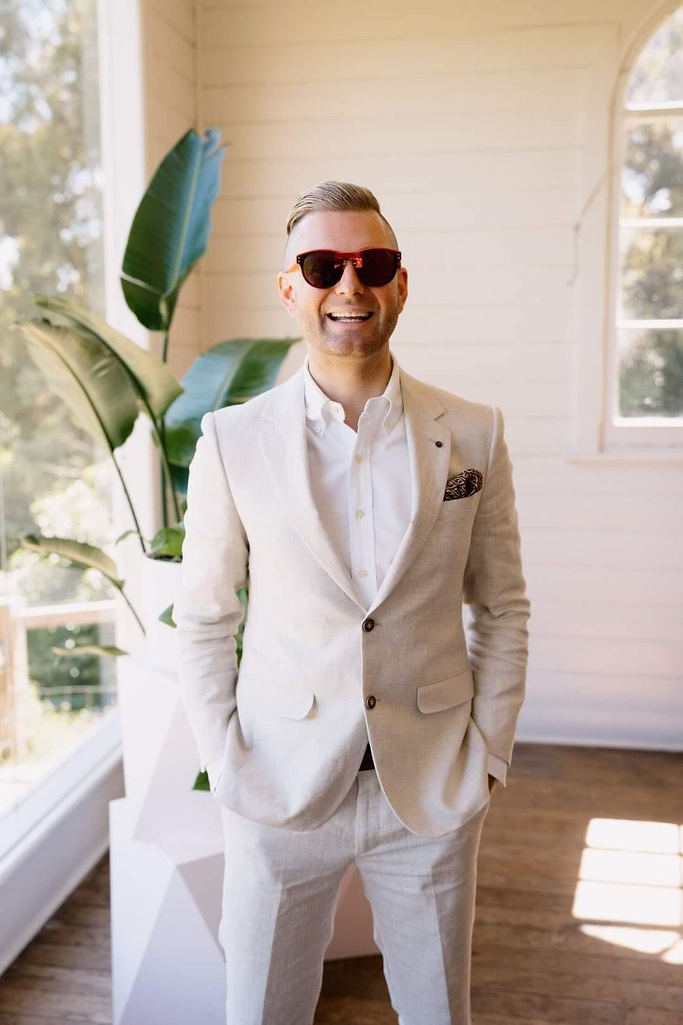 A smiling man wearing sunglasses and a suit, Melbourne Cityside Celebrant.