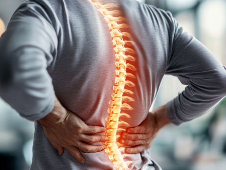 A person holding his lower back in pain with the spine highlighted