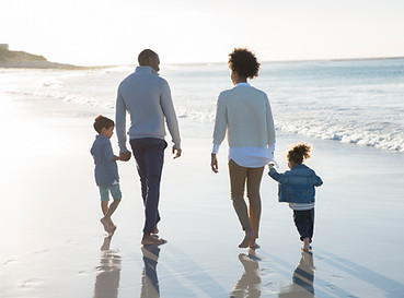 Image of parents with young kids walking on a beach