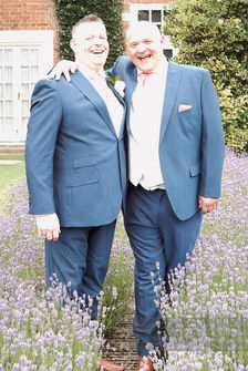Two grooms smiling and posing for wedding photos, wedding photography, outdoor scene
