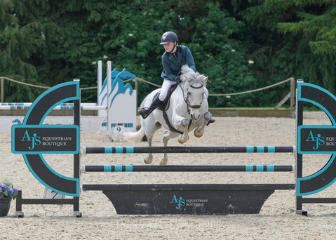 Young rider on a white horse jumping a fence, AJS EQUESTRIAN BOUTIQUE, equestrian photography.