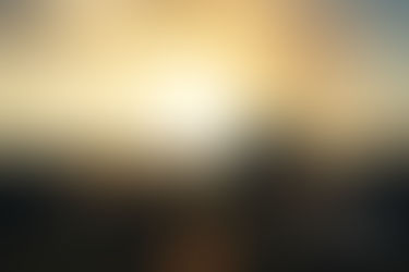 Golden sunrise over rocky moorland, bright sunburst behind a silhouetted rock; watermark text in lower right.