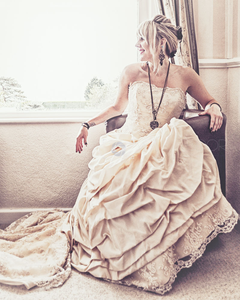 A bride looking out of the window in a vintage dress