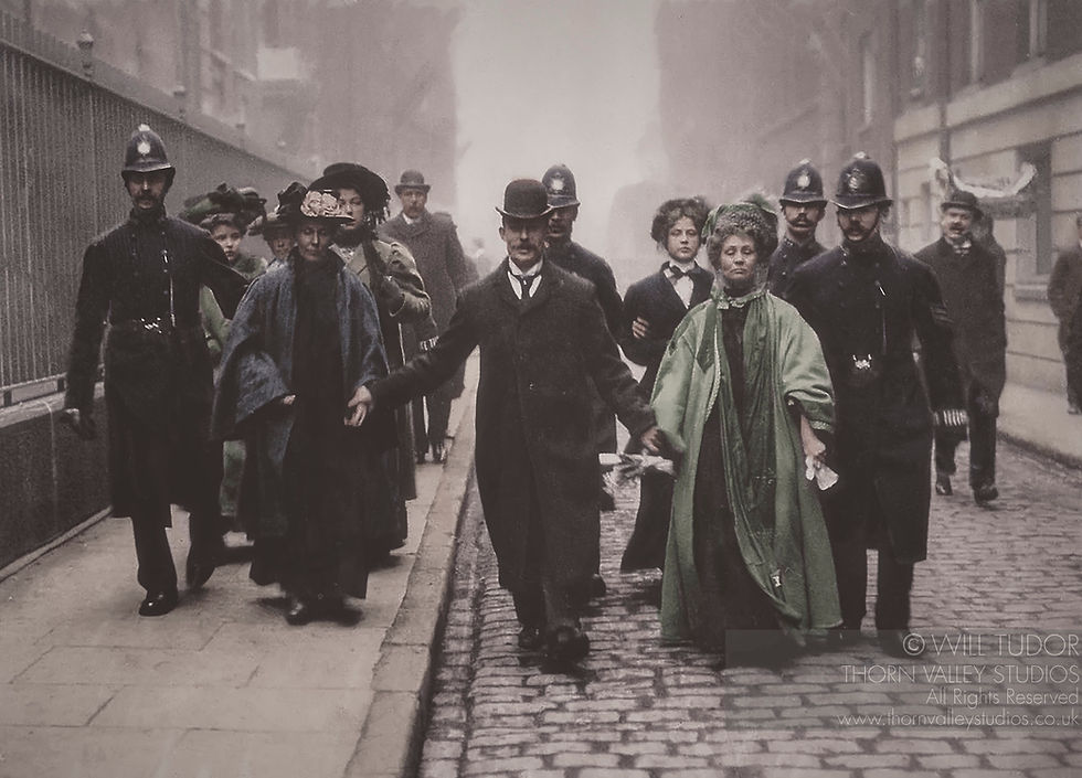 Uniformed police escort a crowd of Edwardian men and women down a foggy cobblestone street, with two women in green and blue cloaks अग्र?