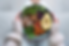 Hands holding a colorful salad bowl with avocado, greens, rice, and veggies. Person wears cozy knitted sweater. Calm, healthy setting.