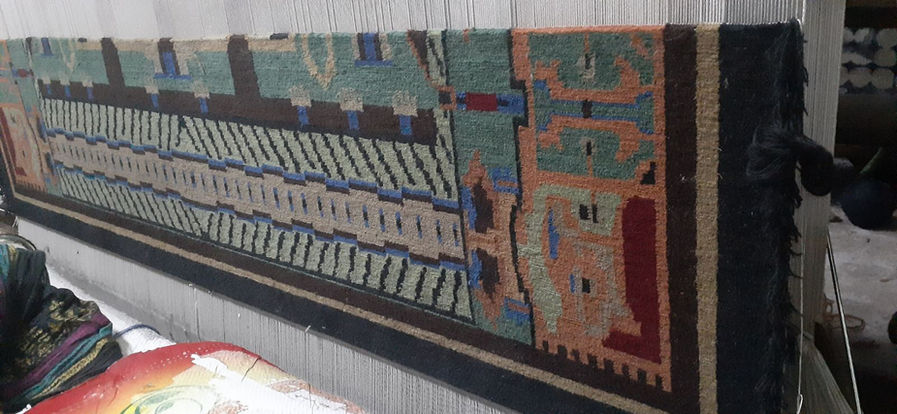 Hand-knotting the rug on the loom.