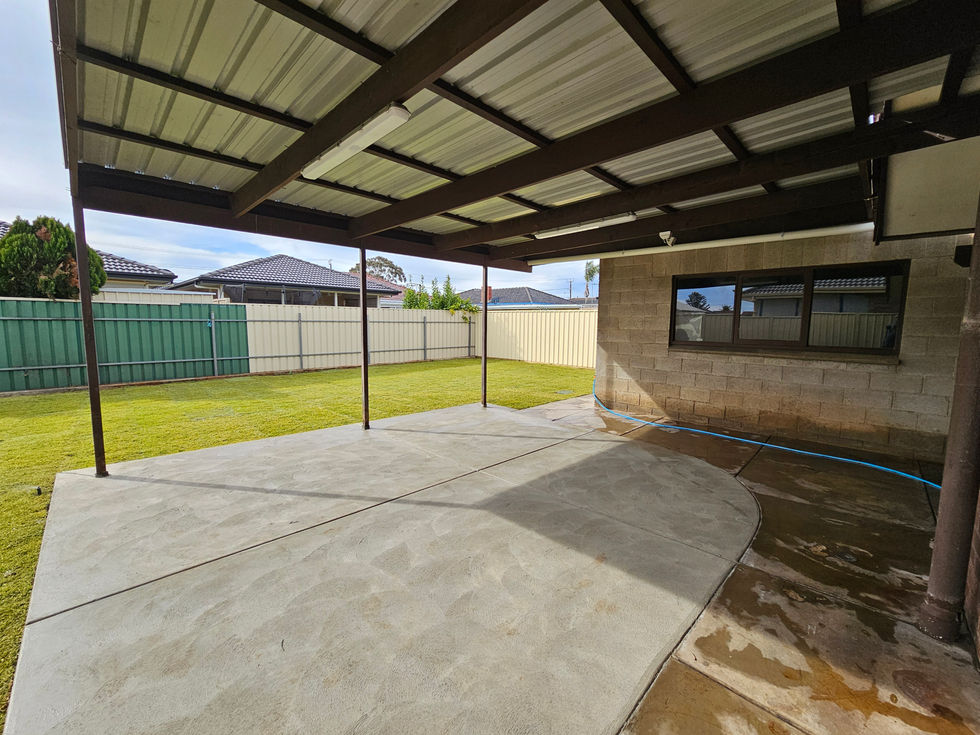 Covered patio with concrete floor and grassy yard.