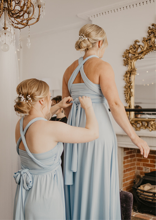 Bridesmaids quietly assisting each other into their dresses at Chichester Harbour Hotel styled by Toni Todd Bridal