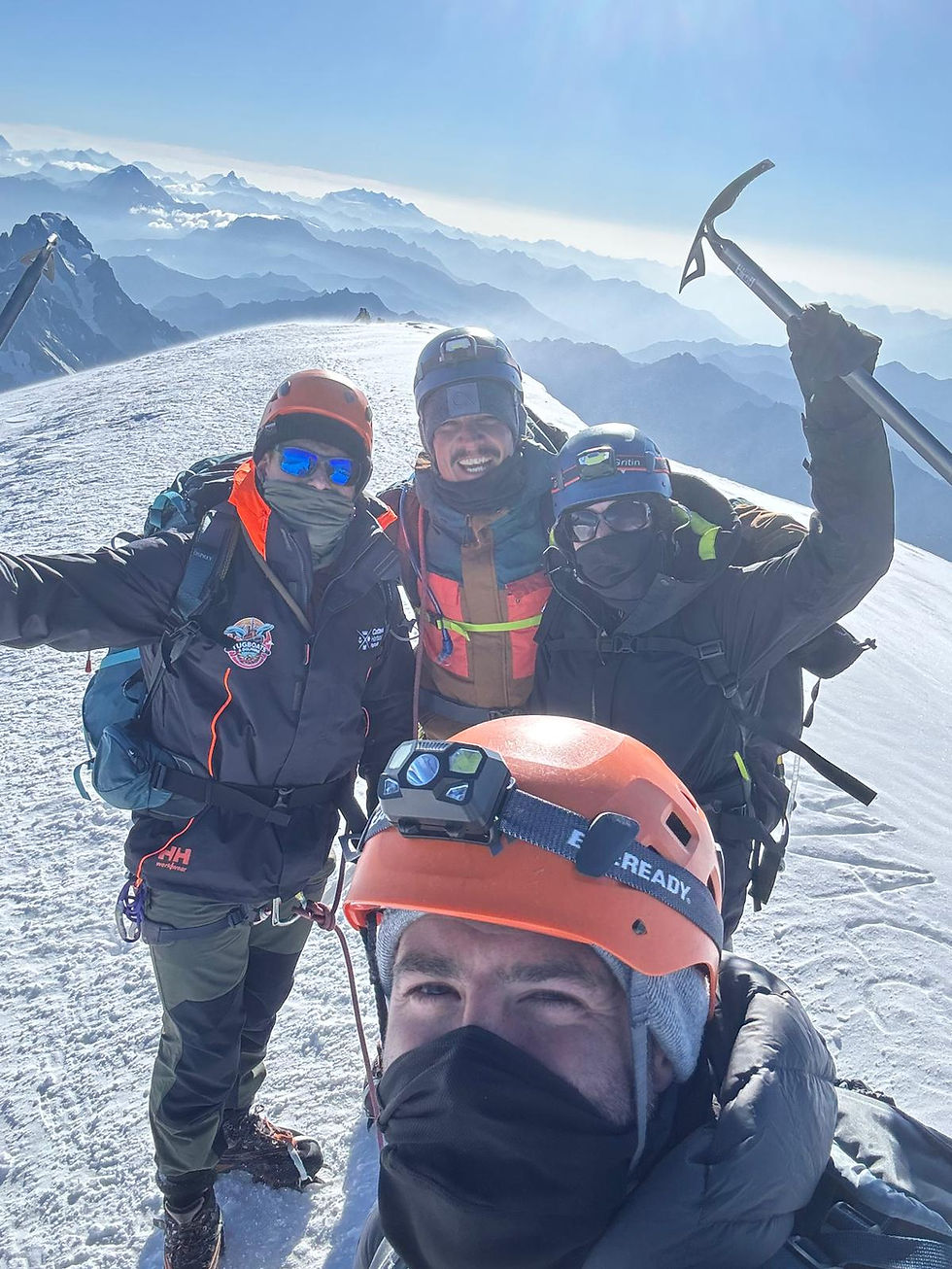 Group of mountaineers celebrating on a snowy mountain peak