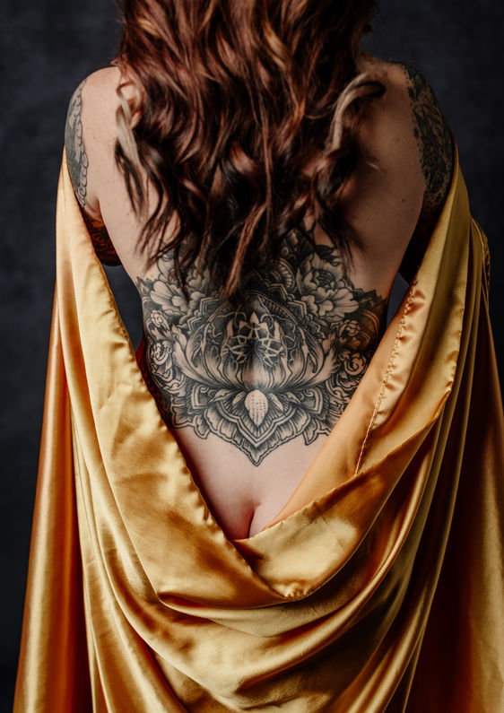 Artistic dark feminine boudoir-inspired portrait of a woman with a silk wrap during a luxury dark glamour photoshoot in Central Florida