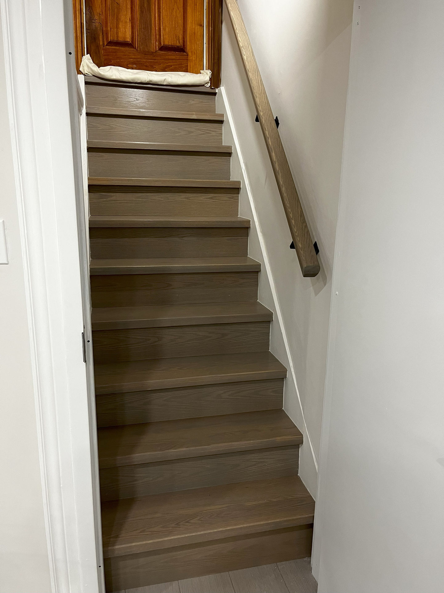 Basement staircase with brown railing