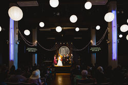 A Chinese couple getting married under large sphere lights and string lights.