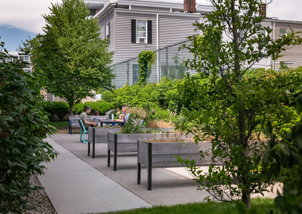 group of people sitting at a picnic table among raised garden beds - Crowley Cottrell LLC Landscape Architecture
