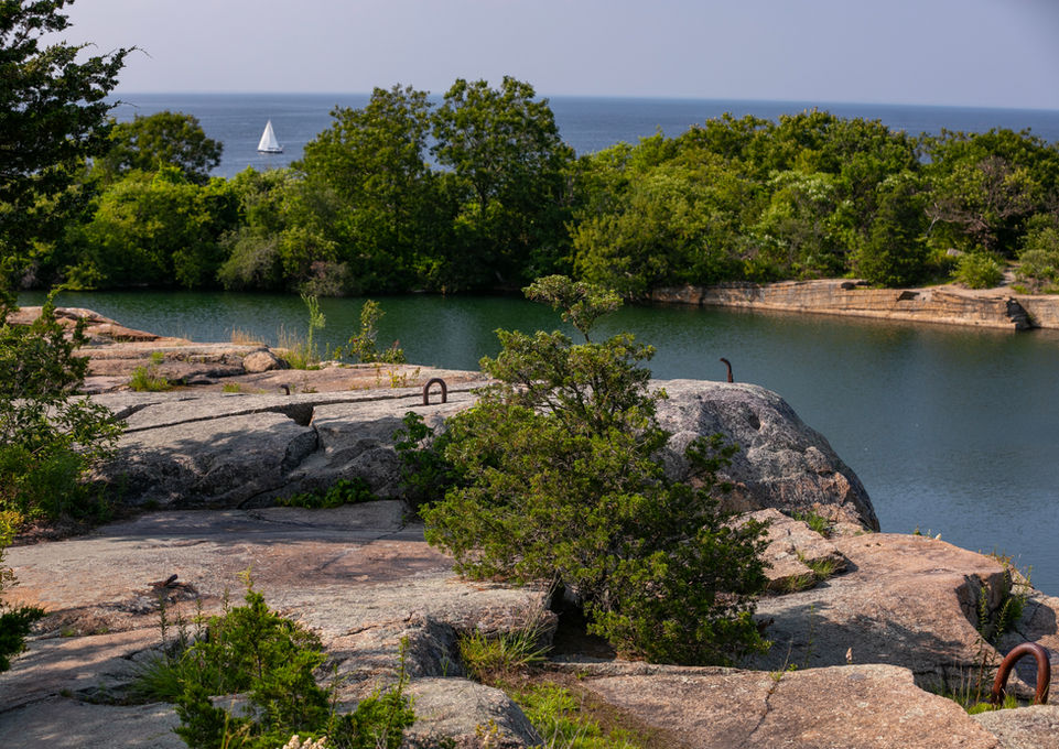 Rock quarry overlook at Halibut Point State Park with sailboat and ocean in the background -Crowley Cottrell LLC Landscape Architecture