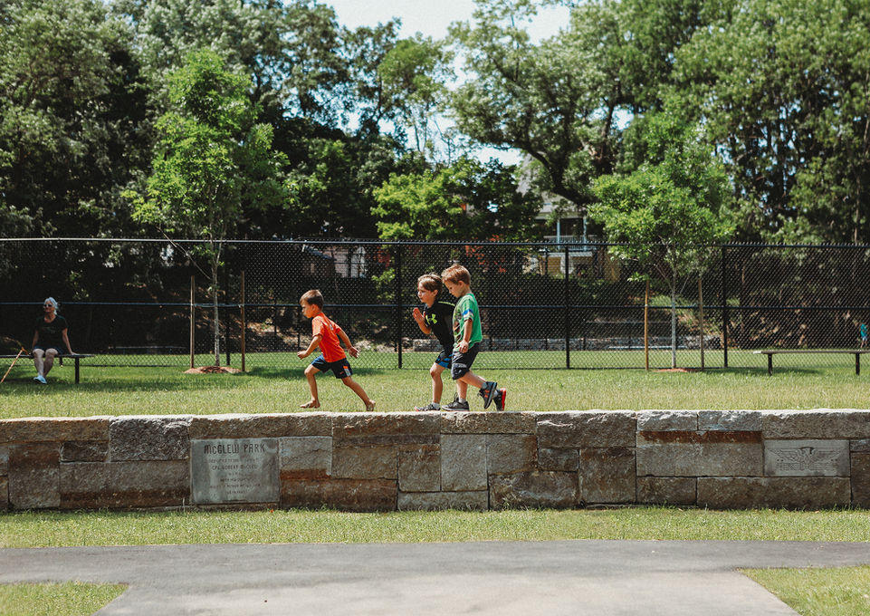 Children running on stone wall at McGlew Park - Crowley Cottrell LLC Landscape Architecture