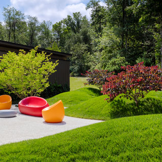 patio with modern brightly colored furniture surrounded by earthwork.